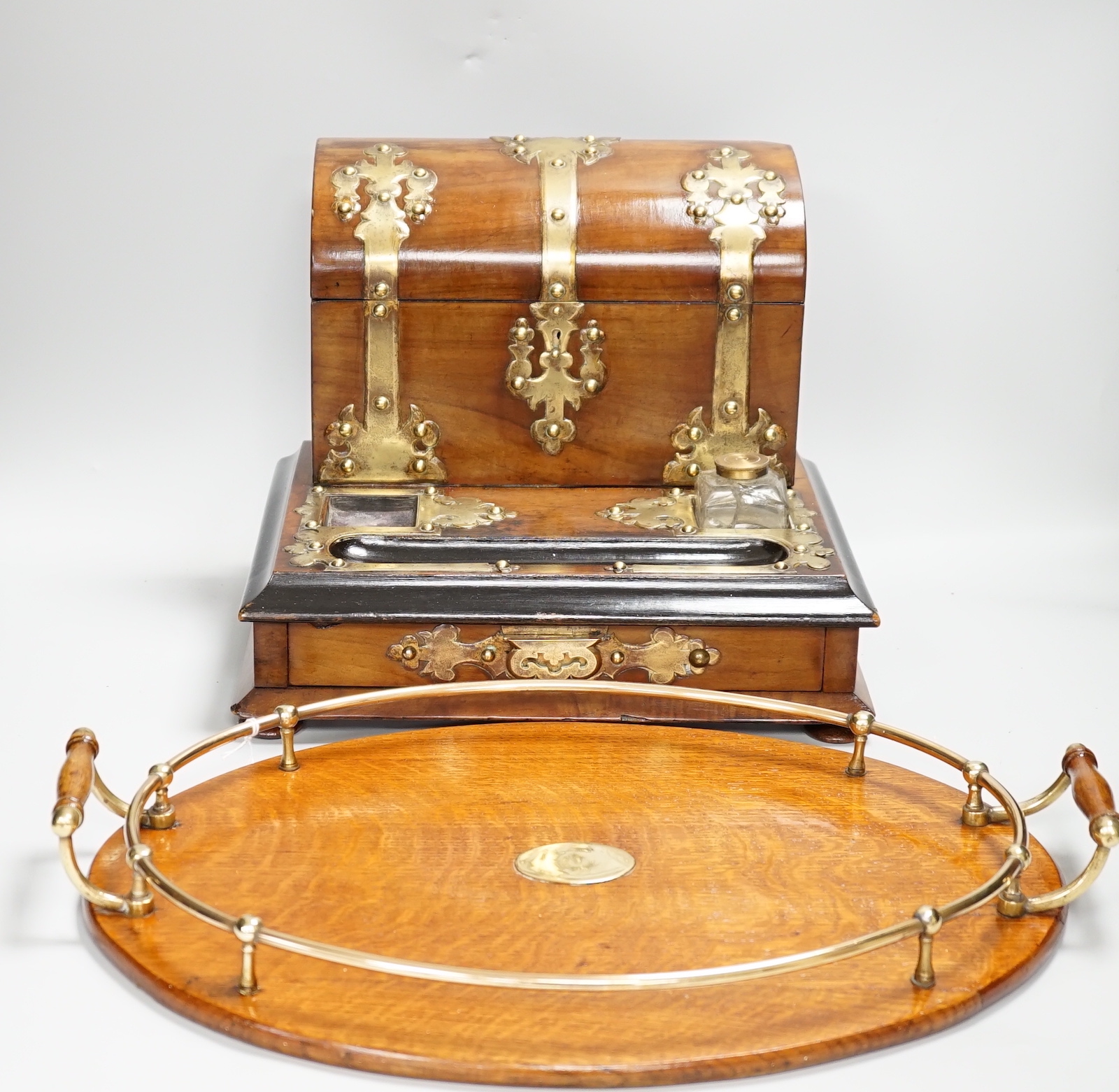A Victorian walnut brass mounted dome topped stationery box and ink stand and an oval oak and a brass two handled tray, stationery box 25cm high